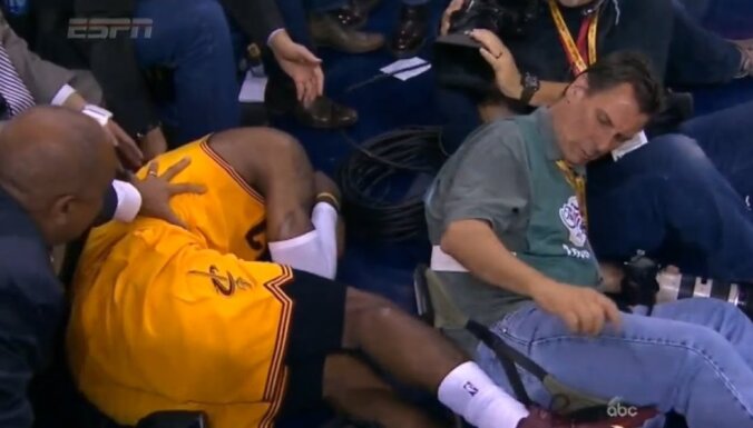 Cleveland Cavaliers forward LeBron James falls into a camera man
